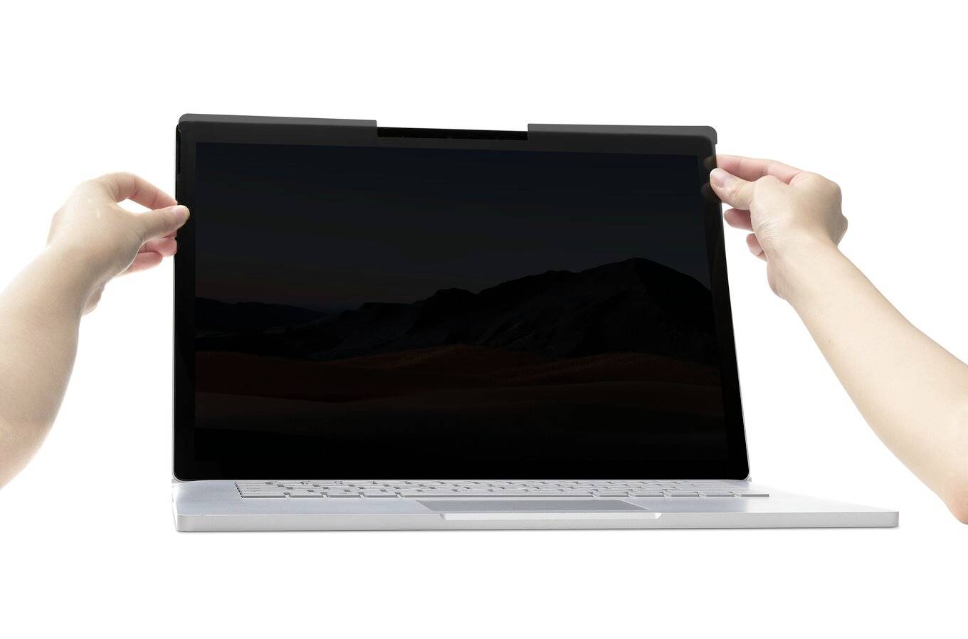 Dwie ręce trzymają ekran laptopa z zamontowaną folią ochronną prywatyzującą. Ekran jest skierowany w stronę użytkownika.