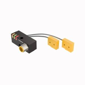 Prostokątny czarny element elektroniczny z dwoma żółtymi kwadratowymi komponentami, połączonymi szarymi przewodami.