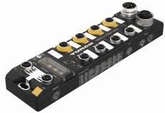 Czarny moduł I/O firmy Turck z żółtymi złączami, okrągłym wtykiem i wieloma portami na górnej powierzchni. Nadaje się do zastosowań przemysłowych.