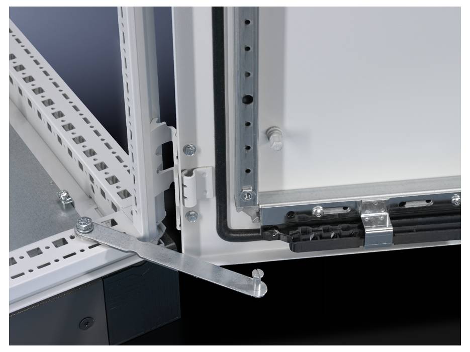 Szafa z otwartymi drzwiami, ukazująca zawiasy i zamki drzwi. Widoczna są drążek montażowy i przewody.