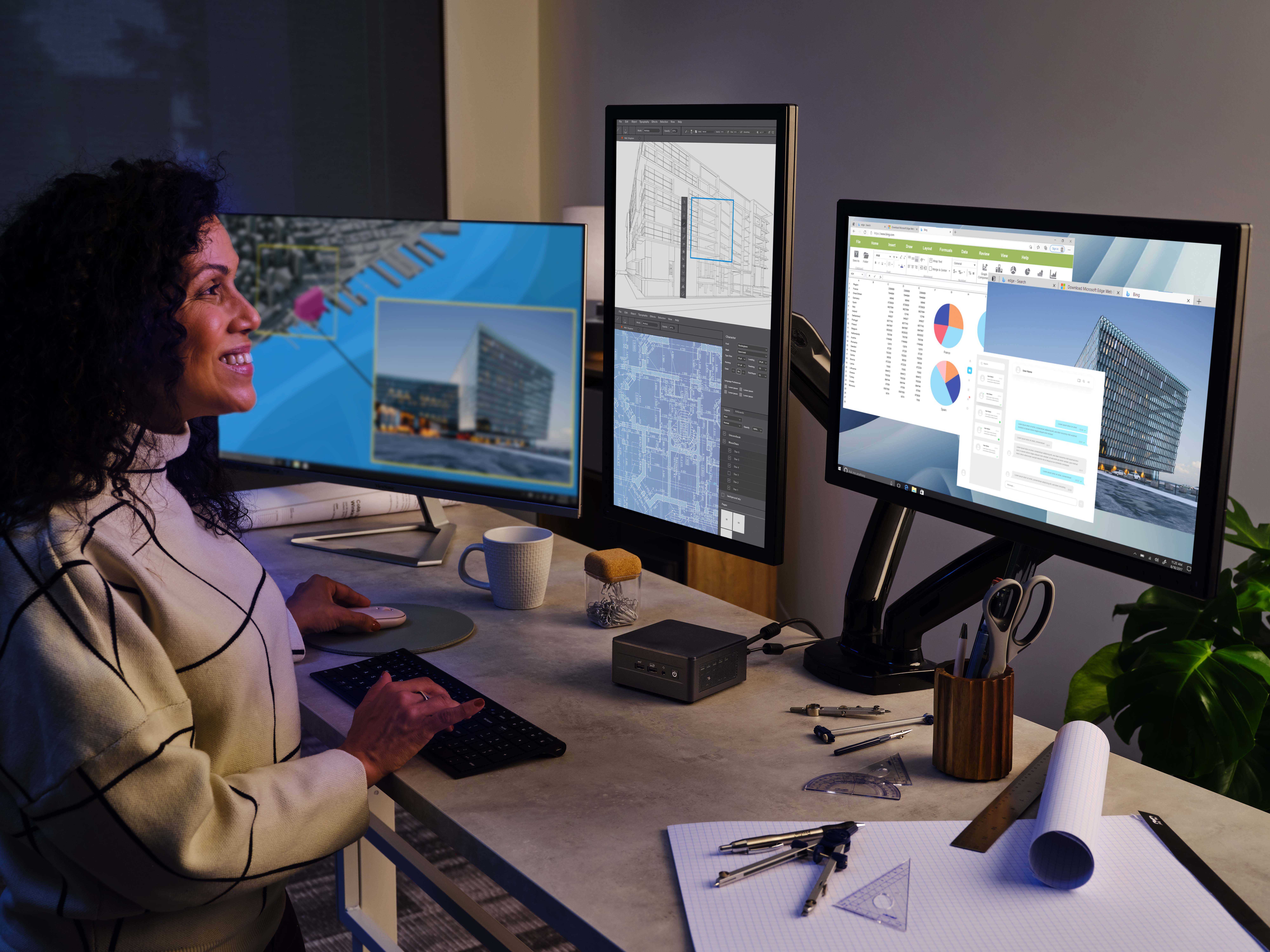 Kobieta pracuje przy biurku z czterema monitorami. Na ekranach widoczne są diagramy i plany budowlane budynku.