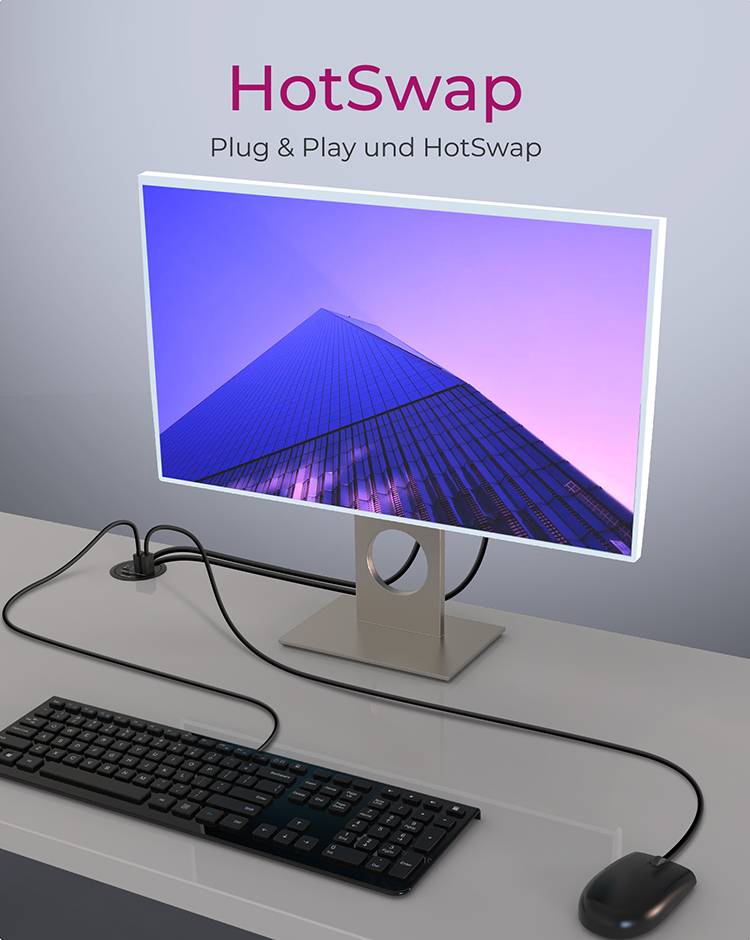 Monitor wyświetla wieżowiec widziany od dołu. Na górze widnieje napis 'HotSwap'. Na dole, na stole, znajduje się klawiatura i mysz.