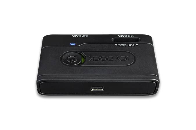 Czarny, prostokątny elektroniczny sprzęt z gniazdami na przedniej stronie oraz przyciskiem na górnej powierzchni.