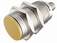 Cylindryczny czujnik metalowy z żółtą przednią częścią i gwintem, ułożony poziomo. Oznaczenie 'Turck' na boku.