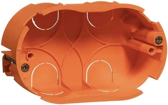 Pomarańczowa puszka instalacyjna z tworzywa sztucznego o owalnym kształcie, przeznaczona do montażu w ścianie. Odpowiednia do instalacji wyłączników lub gniazd elektrycznych.