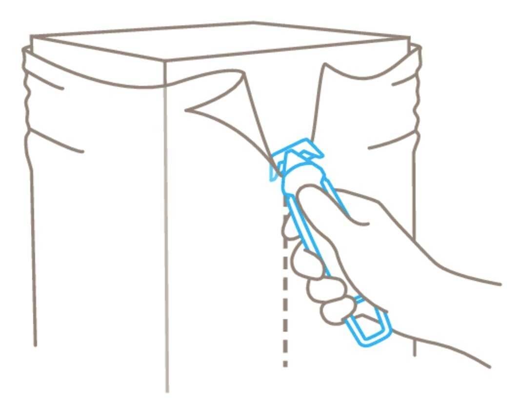 Jedna ręka używa otwieracza, aby rozpiąć zaplombowane szwy torby.