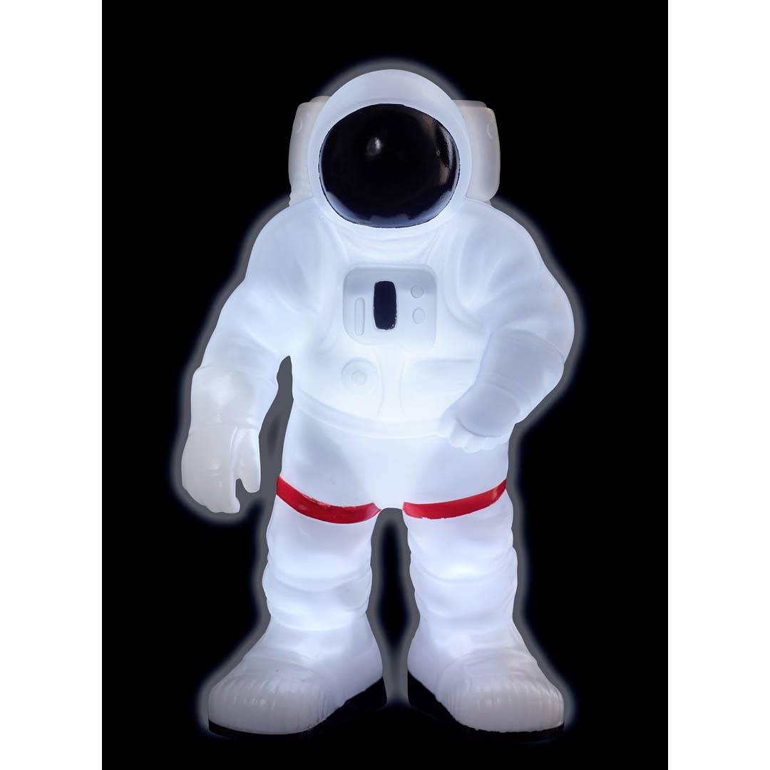 Świecąca figurka astronauty w białym skafandrze i czerwonym pasie stoi na czarnym tle.
