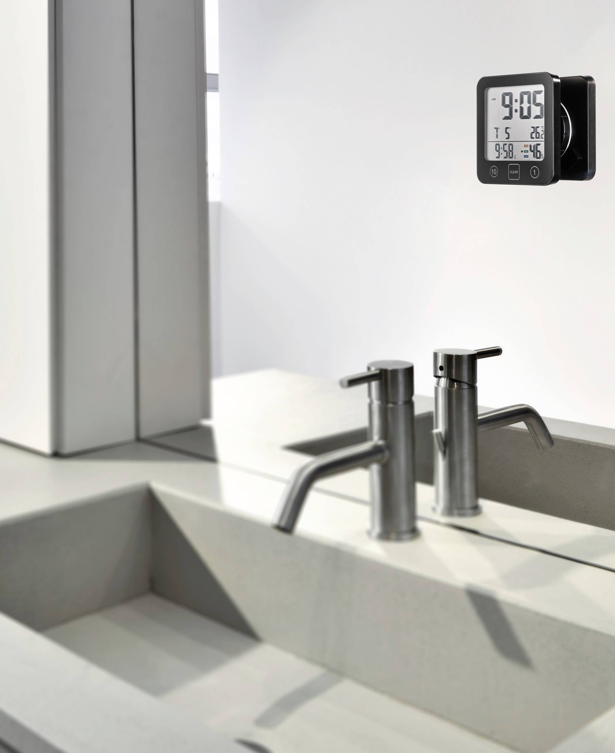 Nowoczesna łazienka z dwoma armaturami ze stali nierdzewnej oraz cyfrowym termometrem ściennym wyświetlającym godzinę i temperaturę.