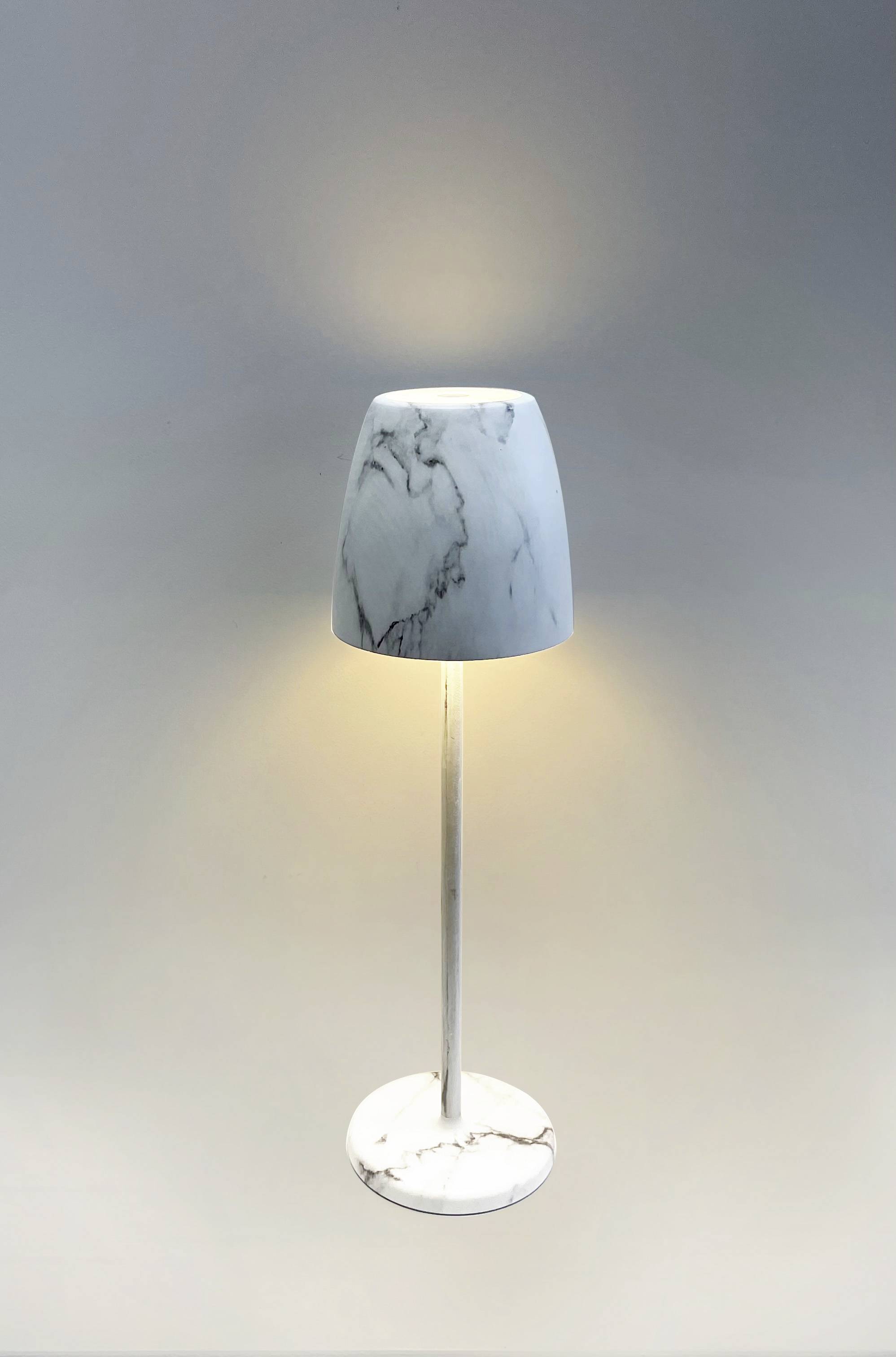 Wysoko połyskująca biała lampa stojąca z marmurowym abażurem i podstawą; emituje miękkie światło rozchodzące się w górę i w dół.