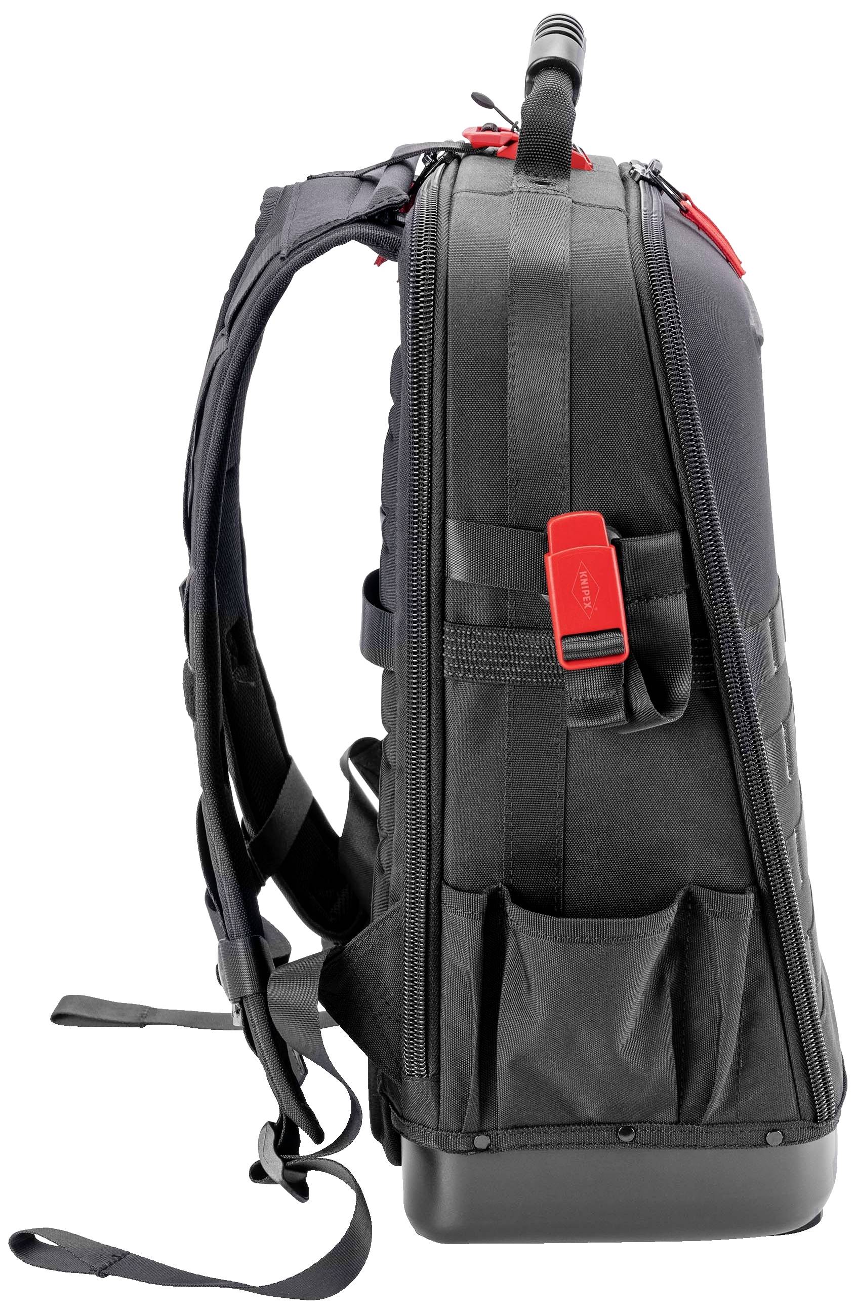 Czarny plecak z wieloma kieszenkami i czerwonym zapięciem na klamry, sfotografowany z boku.