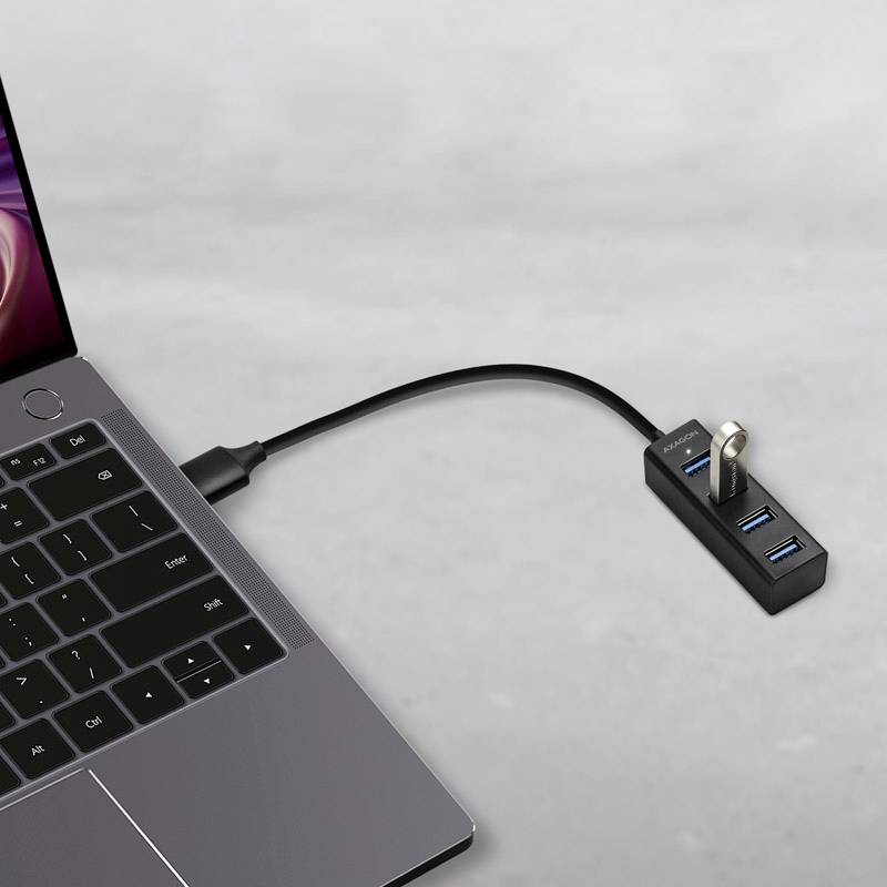 Laptop z podłączonym hubem USB, do którego można podłączyć wiele urządzeń.