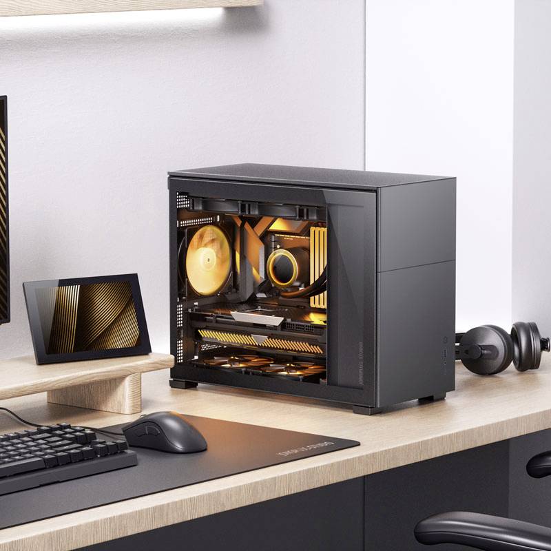 Nowoczesny komputer z podświetlanymi wentylatorami stoi na biurku obok monitora. Scena przedstawia minimalistyczne stanowisko pracy.