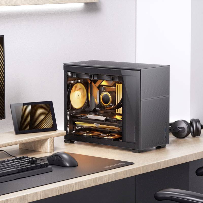 Nowoczesne biurko z otwartą, pomarańczowo podświetloną obudową komputera. Obok monitor, tablet i klawiatura.