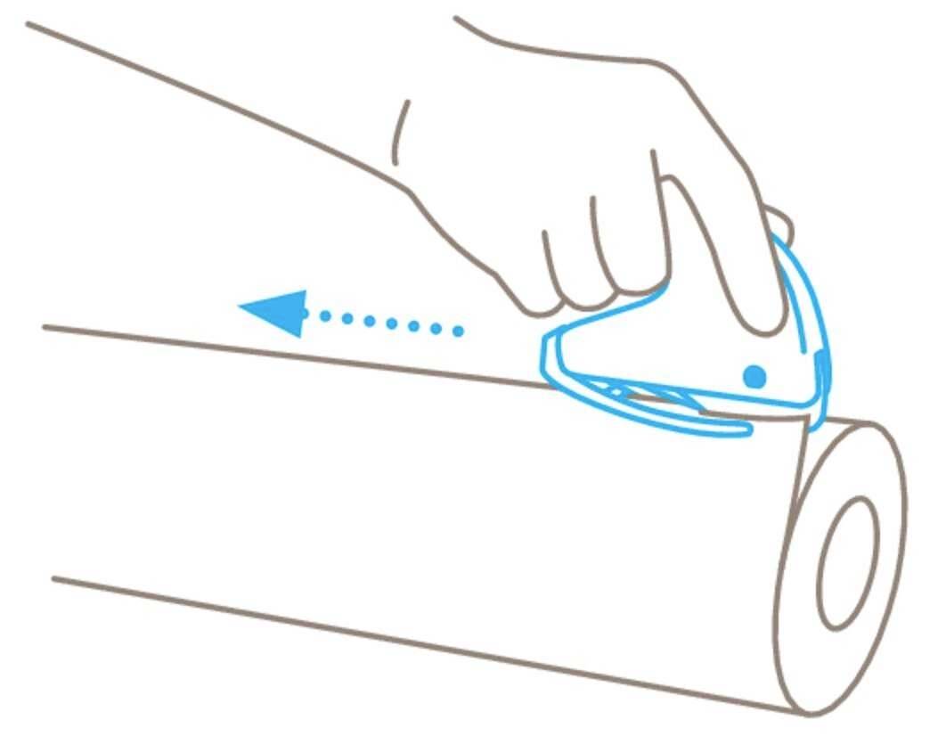 Dłoń używa noża bezpiecznego, aby odciąć kawałek z rolki papieru. Strzałka wskazuje kierunek cięcia.