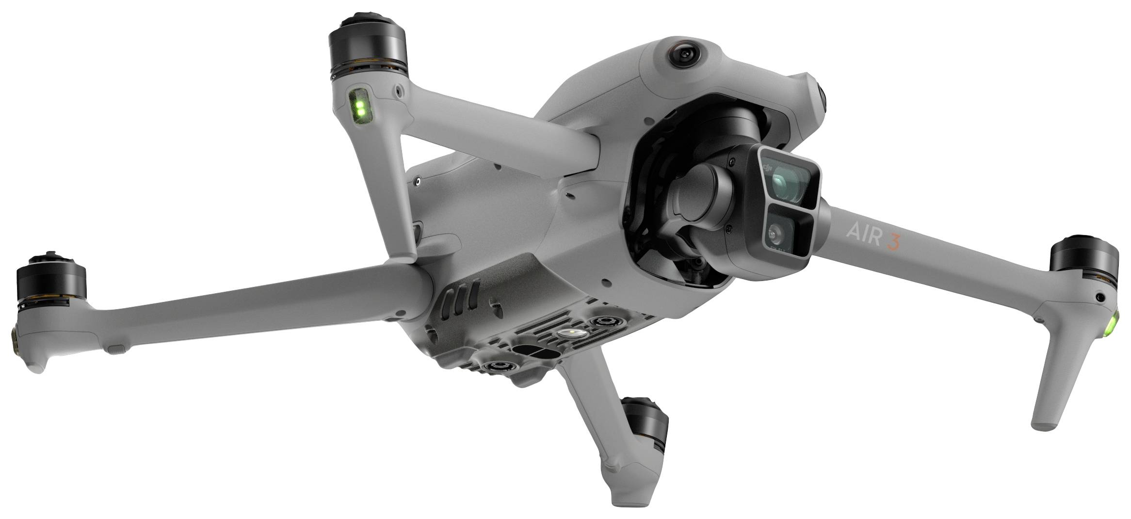 Dron z czterema wirnikami i kamerą unosi się w powietrzu. Jego obudowa jest szara. Jest stabilny i nowoczesny w projektowaniu.