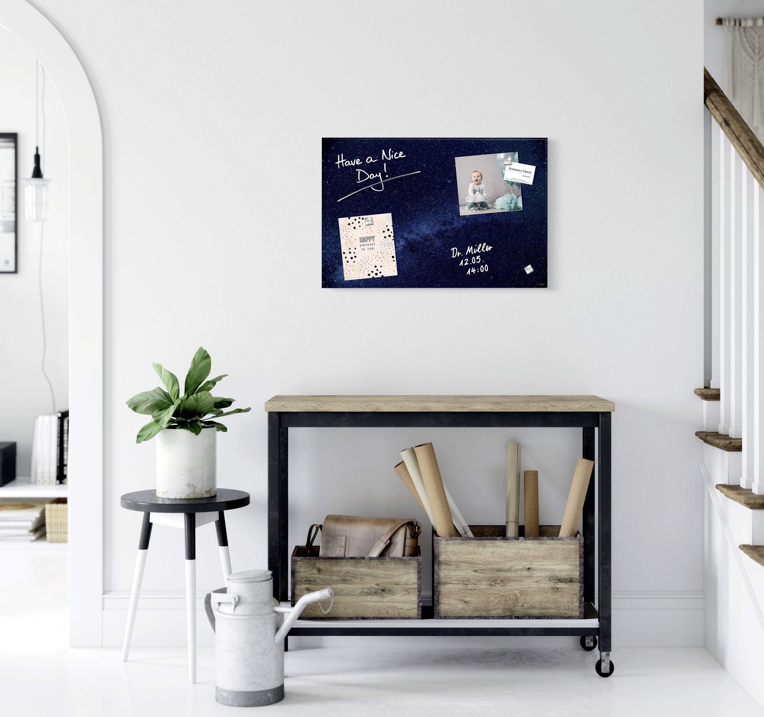 Tablica z napisem 'Have a Nice Day', zdjęciami i notatką. Poniżej stół z roślinami i pudełkami do przechowywania.