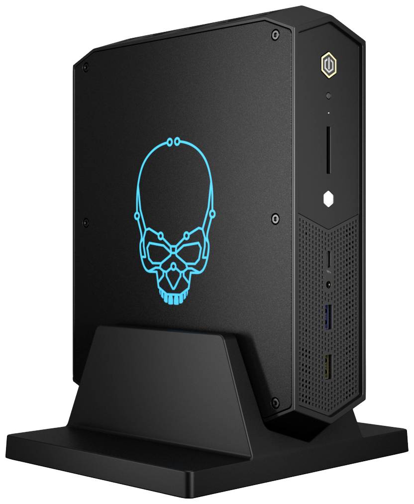 Czarny miniaturowy komputer PC z świecącym niebieskim logo czaszki na boku. Komputer stoi pionowo na podstawce i posiada kilka portów z przodu.