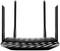 Czarny router Wi-Fi z czterema antenami, nowoczesną obudową i świecącymi diodami LED z przodu, symbolizuje silne połączenie sieciowe.