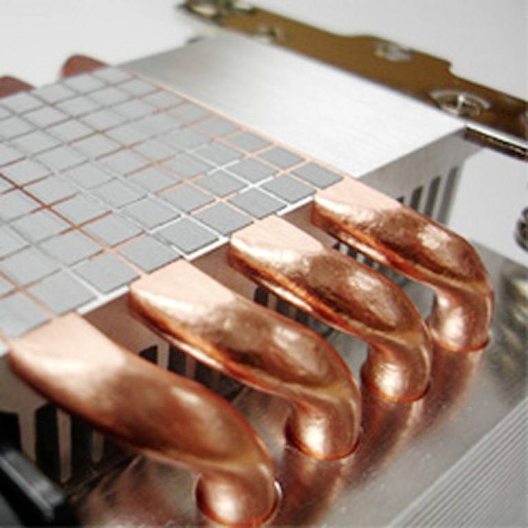 Zbliżenie chłodnicy komputerowej z miedzianymi ciepłowodami służącymi do odprowadzania ciepła z komponentów komputerowych.