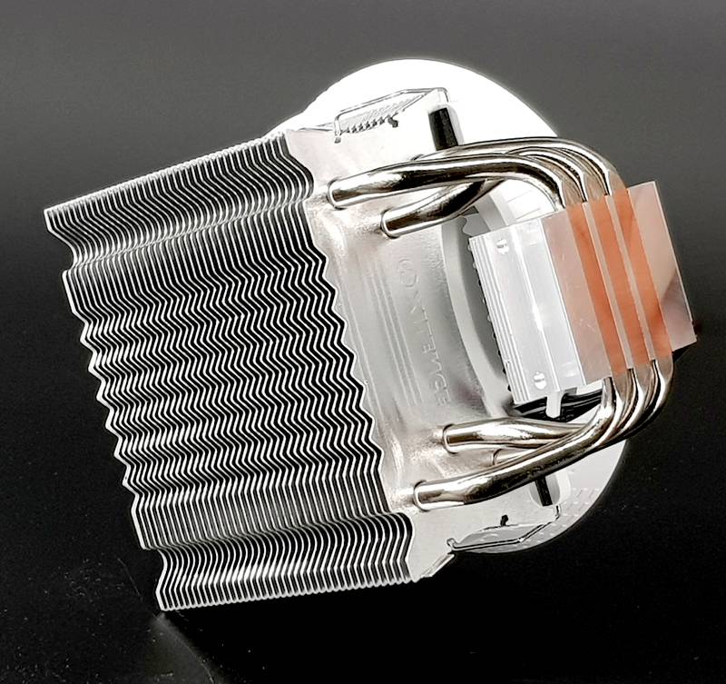 Srebrny metalowy system radiatorów i rurek cieplnych komputera na czarnym tle, przeznaczony do chłodzenia urządzeń elektronicznych.