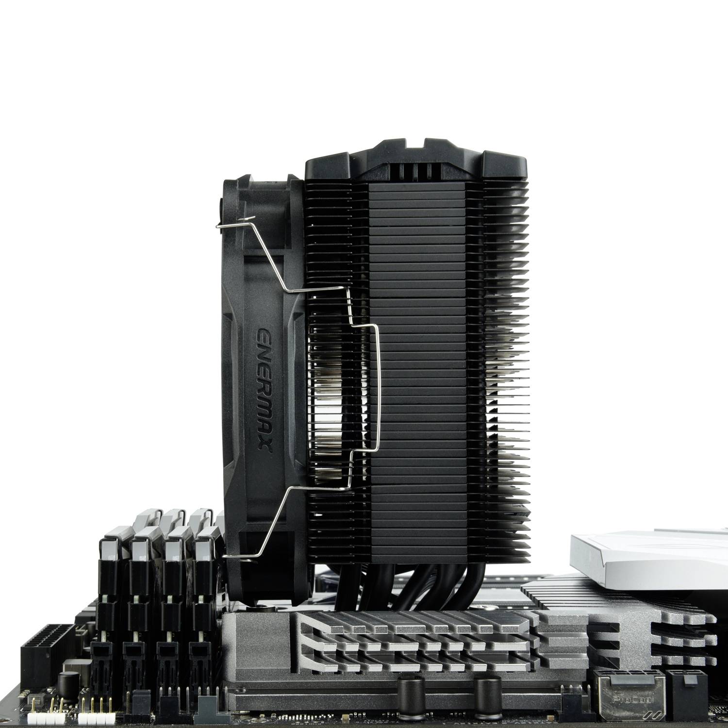 Zbliżenie płyty głównej komputera z modułami pamięci RAM i dużym radiatorem procesora; komponenty techniczne wyraźnie widoczne.