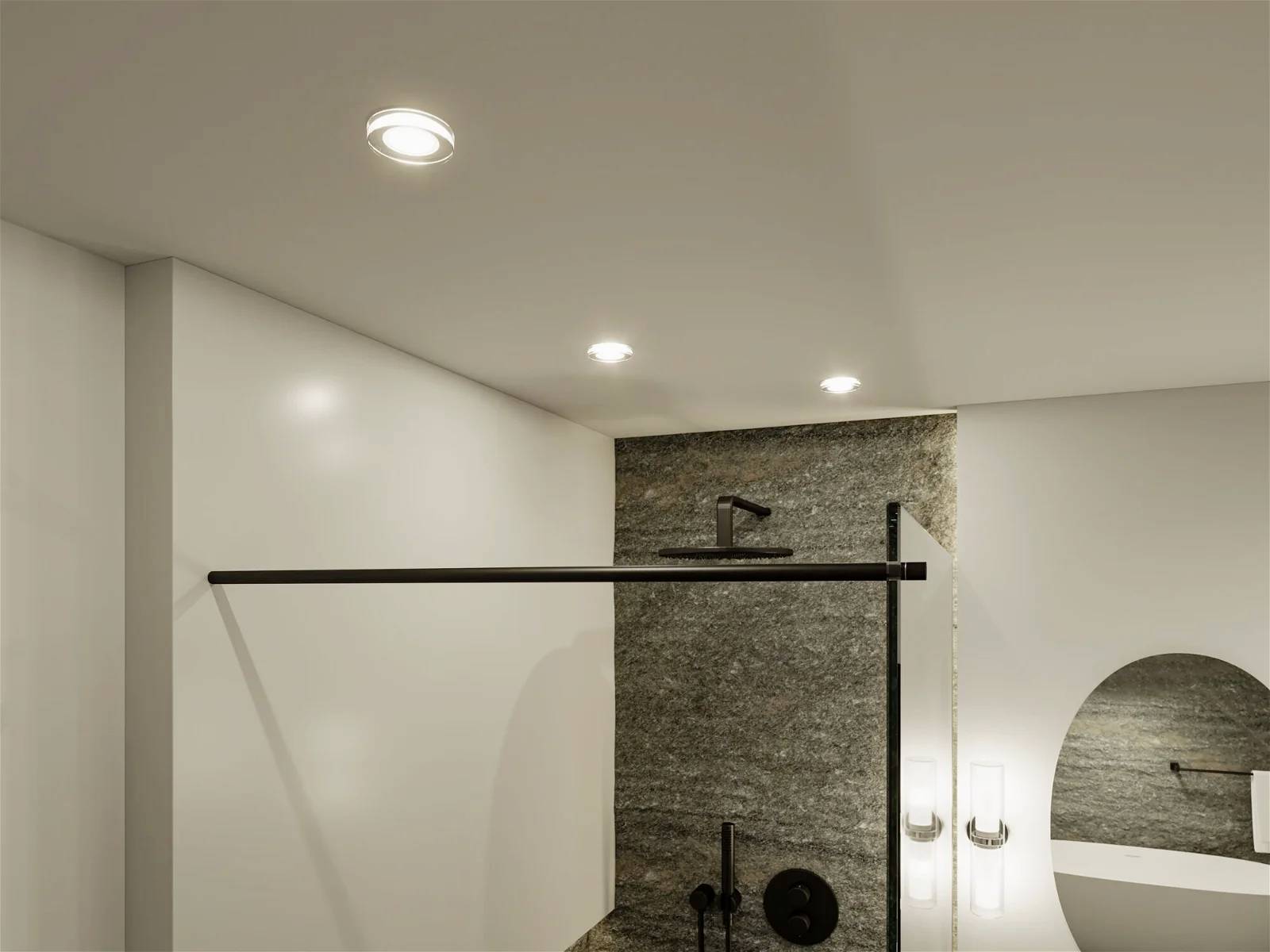 Nowoczesne oświetlenie łazienkowe z wbudowanymi reflektorami sufitowymi nad luksusową kabiną prysznicową i umywalką.