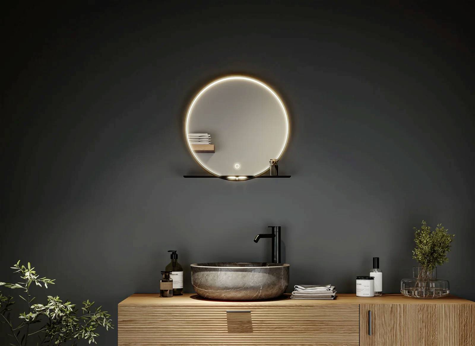 Nowoczesna łazienka z okrągłym, podświetlanym lustrem nad kamienną umywalką. Rośliny i dozownik do mydła zostały dekoracyjnie rozmieszczone.