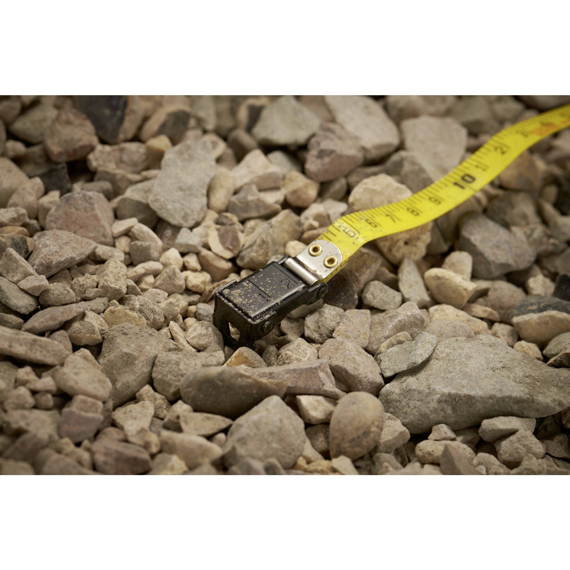 Na żwirowym podłożu leży miarka, wskazując długość około 50 centymetrów.