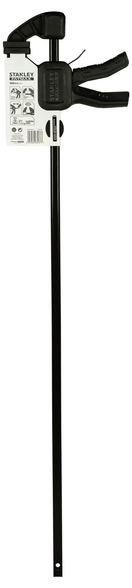 Czarna ścisk śrubowa Stanley z długą rączką i czarną plastikową głowicą. Do narzędzia przymocowana jest etykieta z instrukcją.
