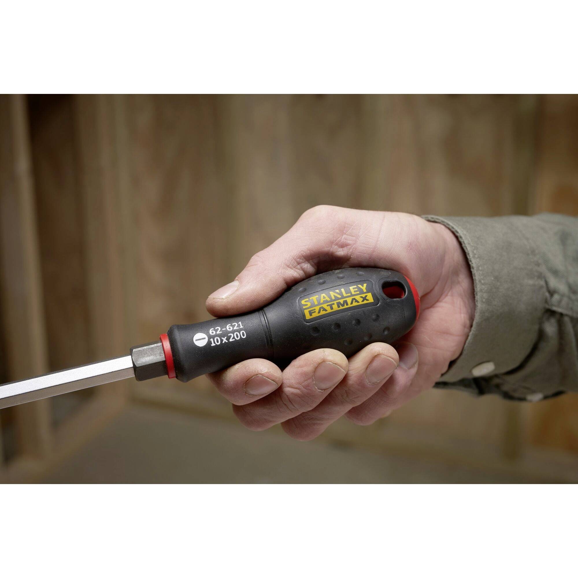 Osoba trzyma wkrętak z czarnym uchwytem i czerwonym czubkiem. Na rękojeści widnieje napis 'Stanley Fatmax'.