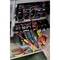Osoba pracuje z izolowanym narzędziem przy otwartej szafie sterowniczej pełnej kabli i elementów elektrycznych.