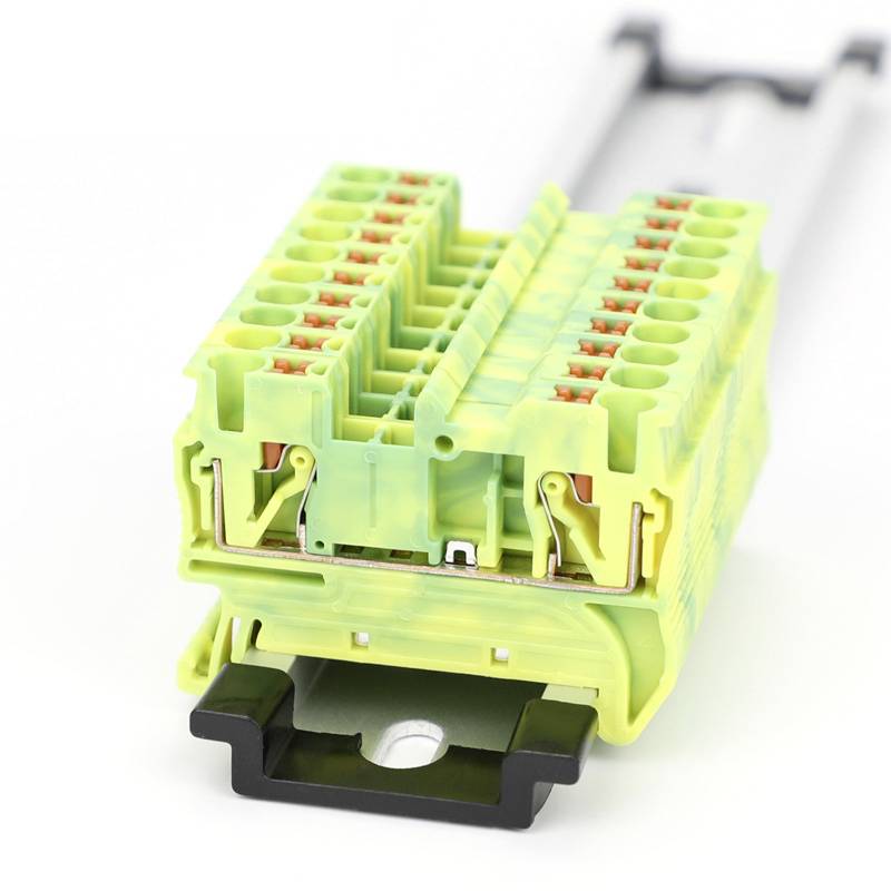 Żółty elektryczny złącz z wieloma zielonymi i czerwonymi przyłączami w ujęciu z bliska.