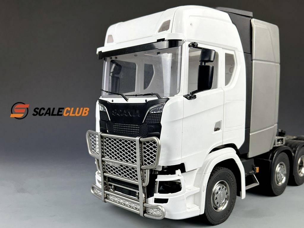 Modelowy samochód ciężarowy z białą kabiną i solidnym zabezpieczeniem przednim stoi przed neutralnym tłem. Napis 'SCALECLUB' znajduje się po lewej stronie.