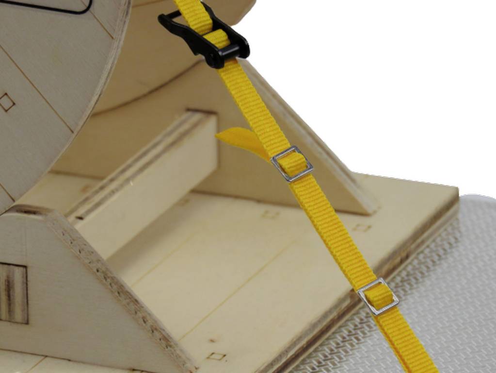 Żółta taśma mocowana na metalowe klamry do drewnianej struktury, służąca do zabezpieczania przedmiotów.