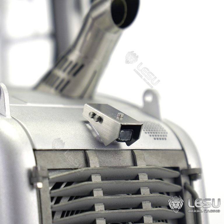 Zbliżenie srebrnego modelu z kratkami wentylacyjnymi i rurą wydechową. Nazwa marki 'LESU' jest widoczna w kilku miejscach.