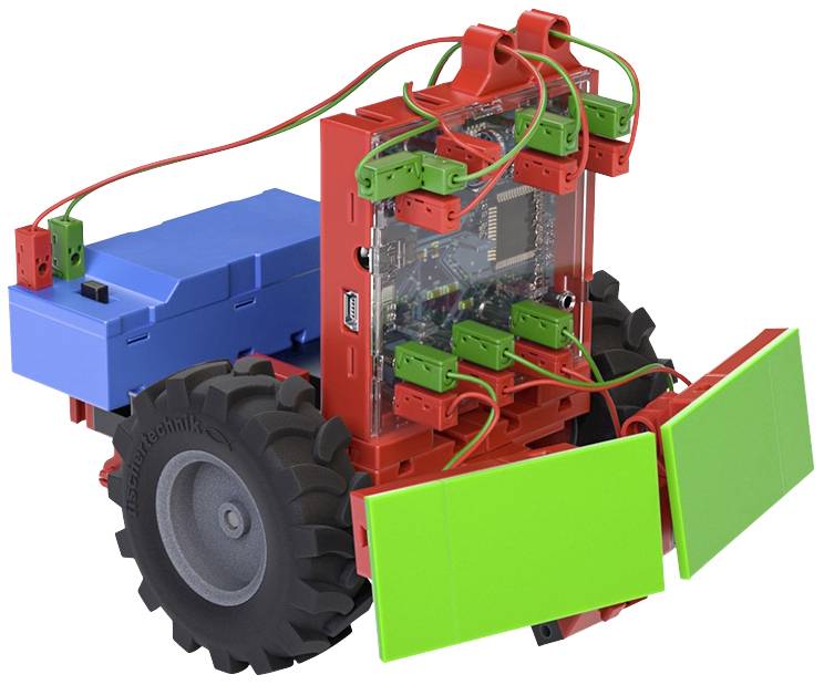 Mały, kolorowy model robota z widocznymi obwodami elektronicznymi i okablowaniem, zamontowany na dużych czarnych kołach.