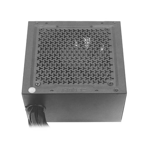 Czarny zasilacz komputerowy w kształcie kwadratu z kratką wentylacyjną na górze. W lewym dolnym rogu widoczne są kable.