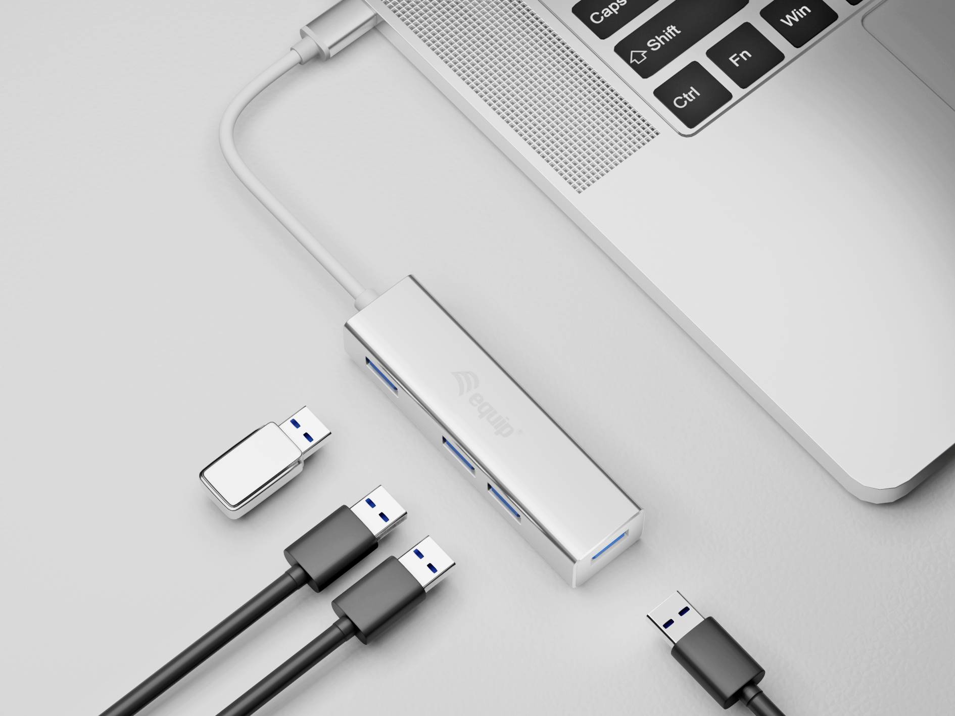 Laptop z podłączonym hubem USB oraz kilkoma pendrivami i kablami. Hub posiada wiele gniazd.