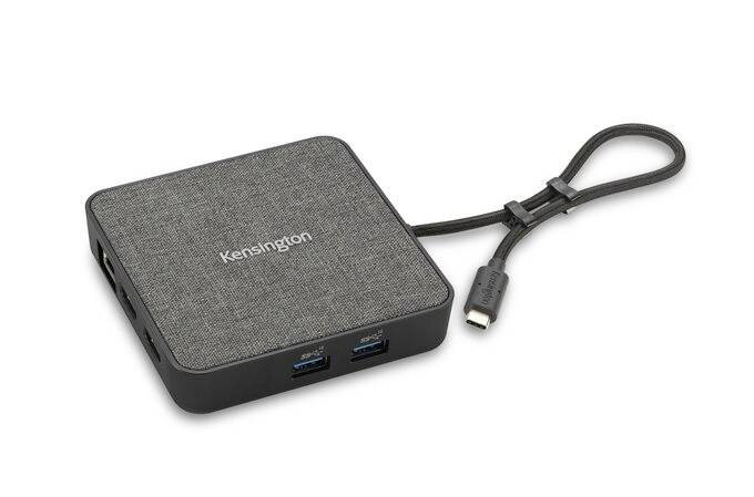Kwadratowy hub USB-C firmy Kensington z tkaniną na powierzchni, wieloma portami i krótkim przewodem przyłączeniowym.