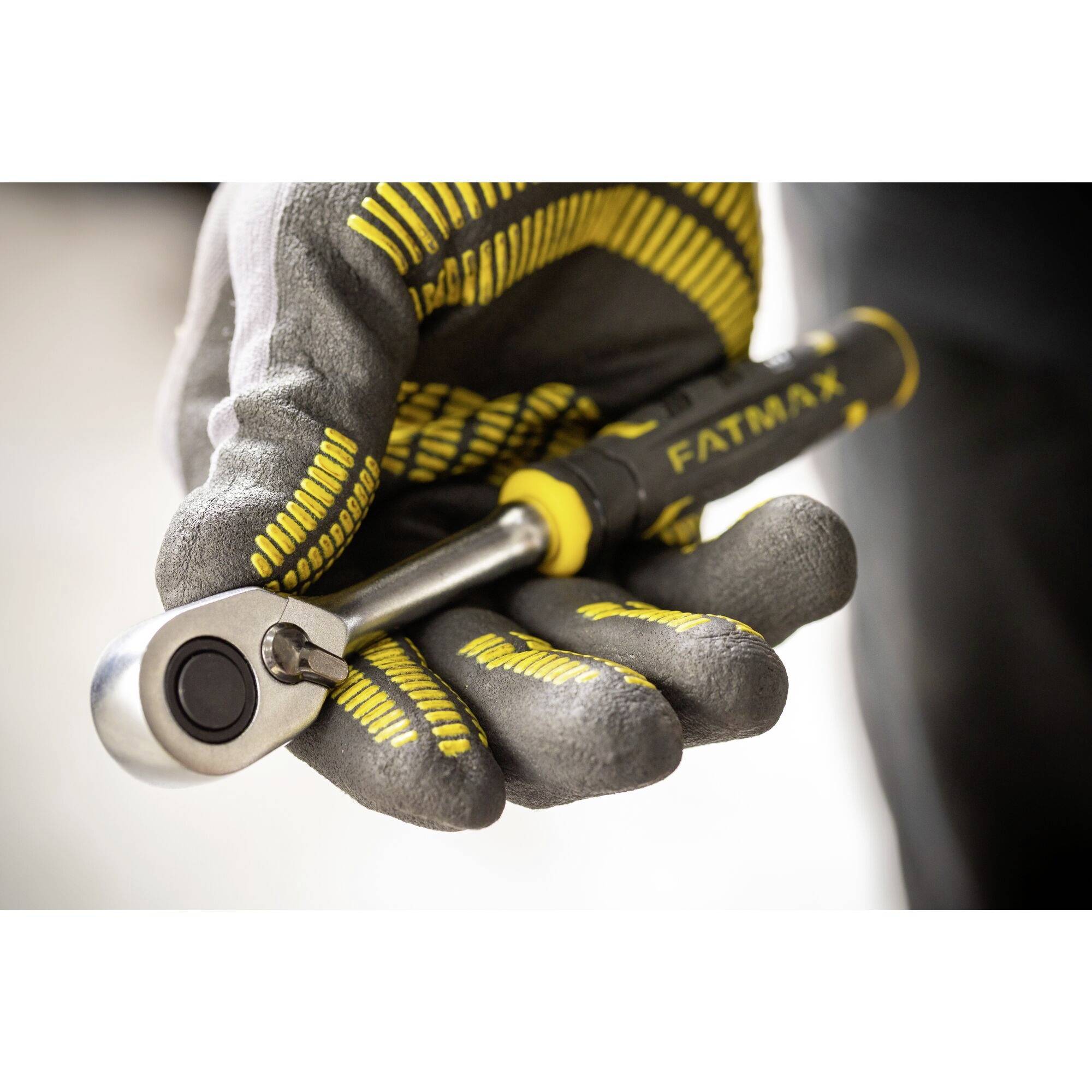 Rękawica trzyma klucz szczękowy z napisem 'FATMAX'. Uwaga skupiona jest na rękojeści i mechanizmie.