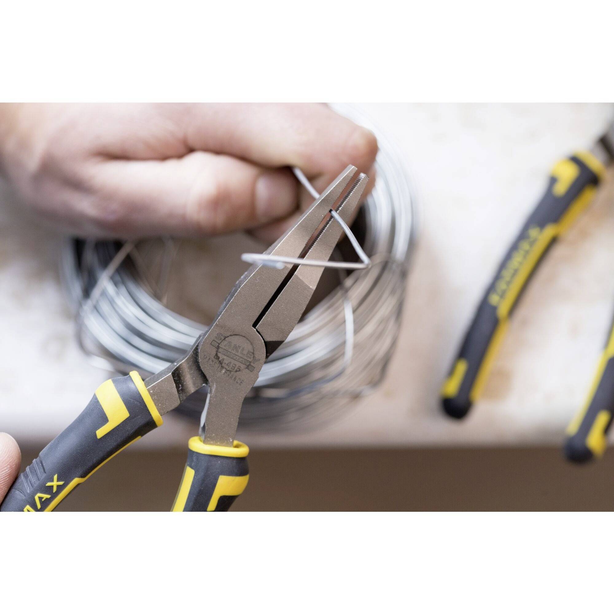 Osoba używa szczypiec do cięcia drutu. W tle widać kolejne narzędzia i drut.