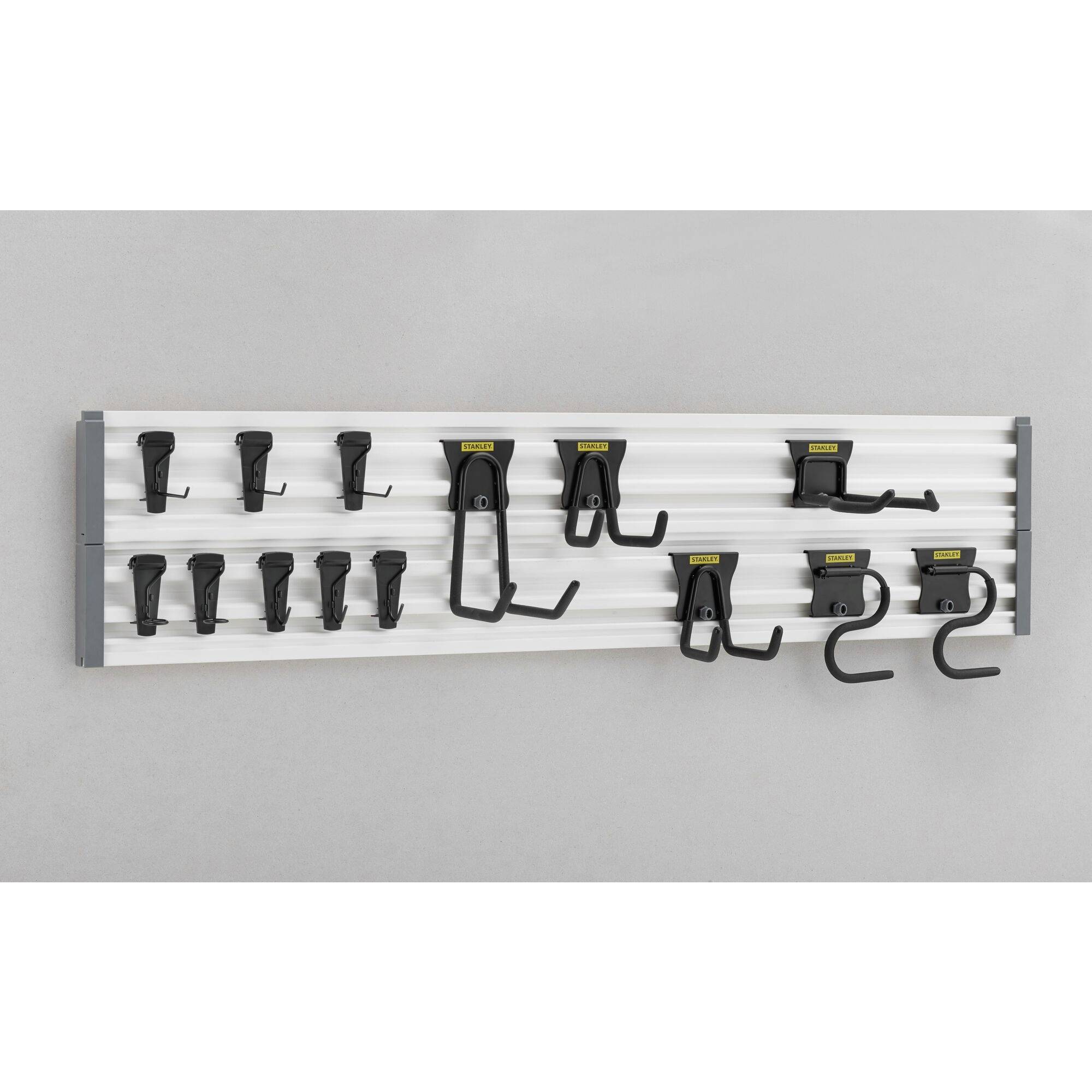 Organizator ścienny z kilkoma czarnymi hakami do przechowywania narzędzi, zamontowany na białej szynie.
