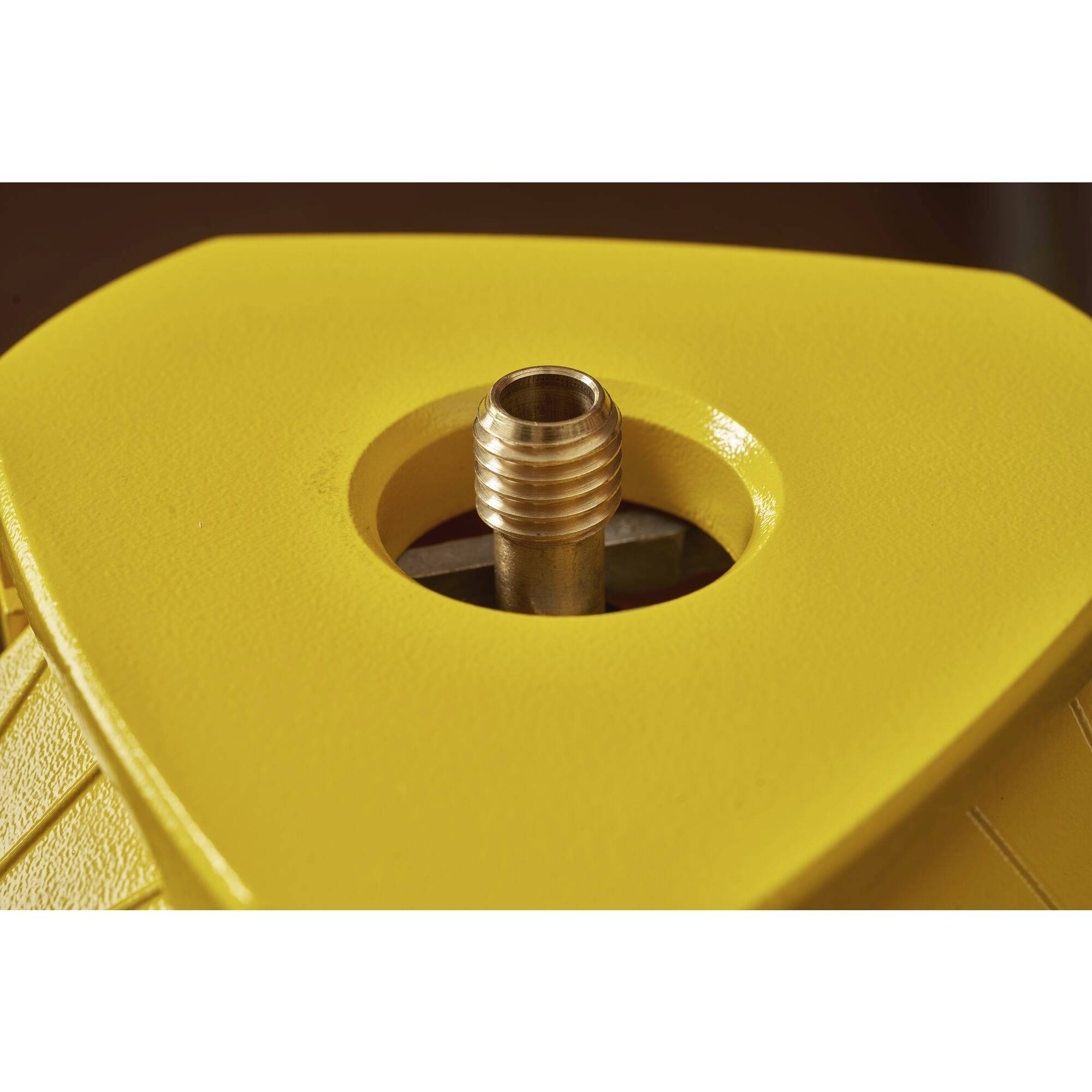 Żółty sześciokątny obiekt z centralnym metalowym dyszem w zbliżeniu.