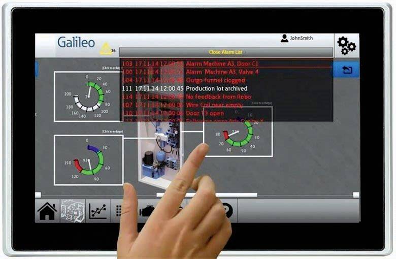 Palec wskazuje na tablet z programem do monitorowania maszyn. Wyświetlane są wykresy i alarmy.
