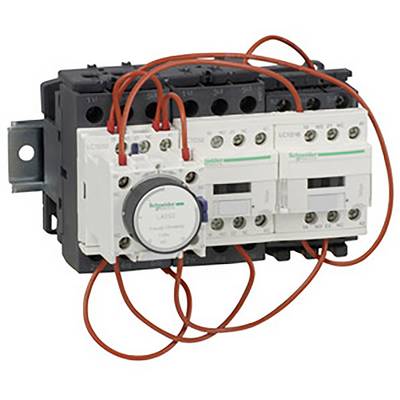 Elektryczny przekaźnik z wieloma czerwonymi przewodami, zamontowany na szynie metalowej, używany do sterowania obwodami elektrycznymi w instalacjach przemysłowych.