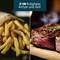 Cyfrowy frytkownico-grill 2 w 1, po lewej stronie frytki, po prawej stek na drewnianym stole.