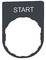Symbol przycisku „START" na czarnym tle, otoczony owalną ramką, prawdopodobnie oznaczający punkt startowy lub przełącznik.