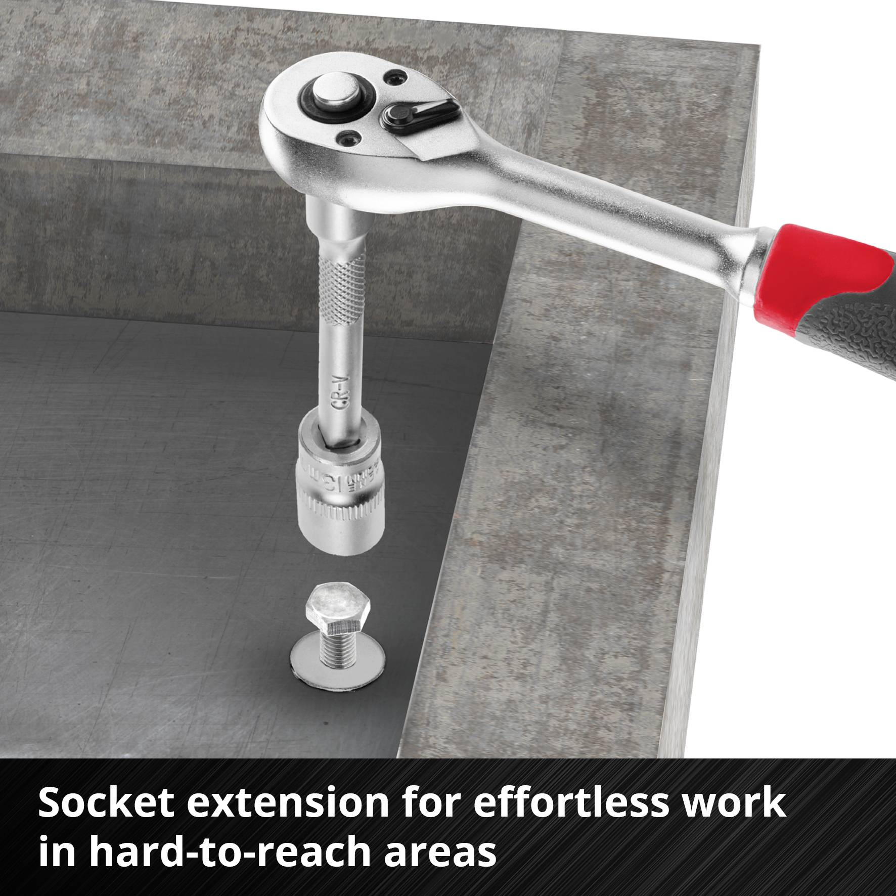 Grzechotka z przedłużką na nasadkę dokręca śrubę w trudno dostępnym miejscu stalowej ramy.