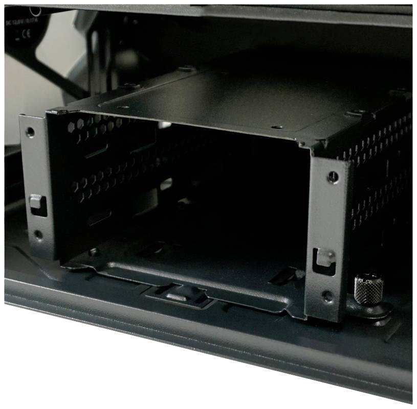 Pusty wewnętrzny slot na dyski w obudowie komputera, gotowy do zainstalowania dysków twardych lub dysków SSD.