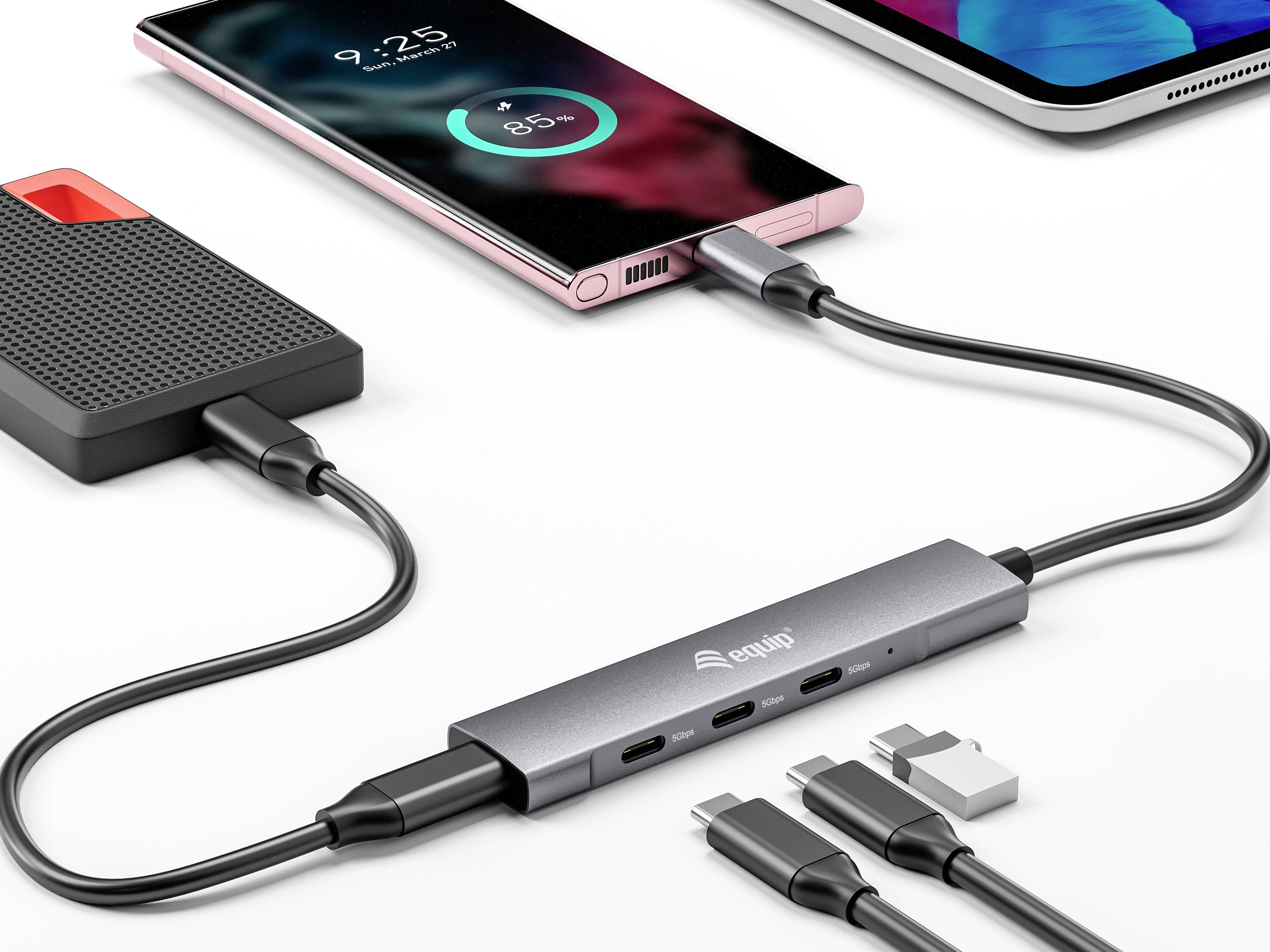 Smartfon jest ładowany przez hub USB-C, który jest również podłączony do zewnętrznego dysku. Wskaźnik procentowy pokazuje 85% naładowania.